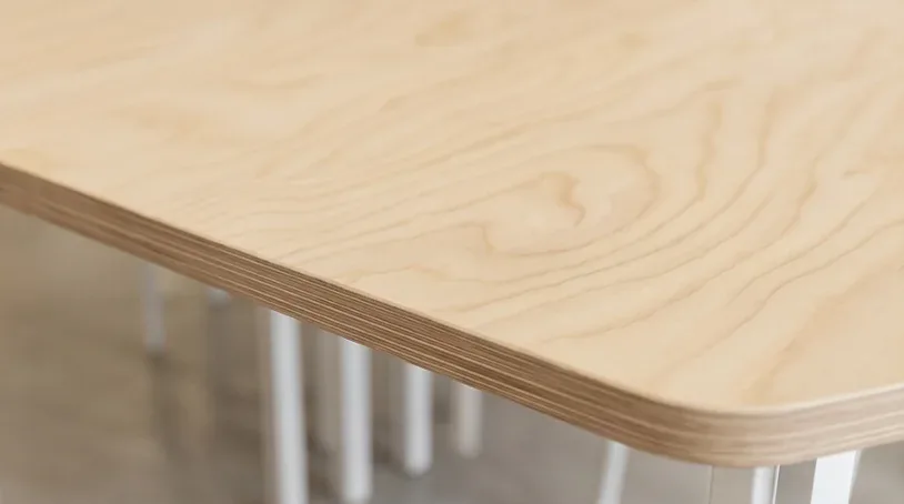 Détail du chant en bois clair d’une table de l’atelier Manoré
