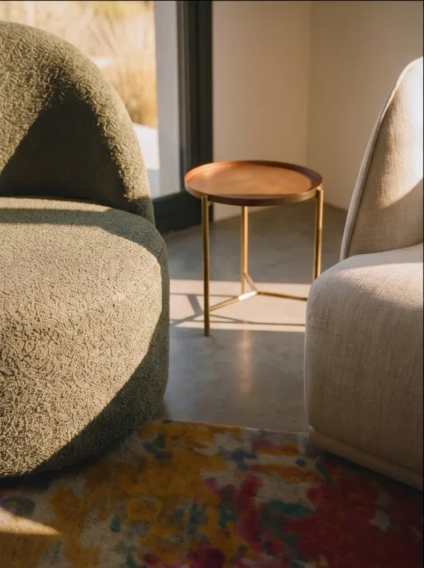 Fauteuil en bouclé et guéridon en bois sur tapis coloré, Combebelle